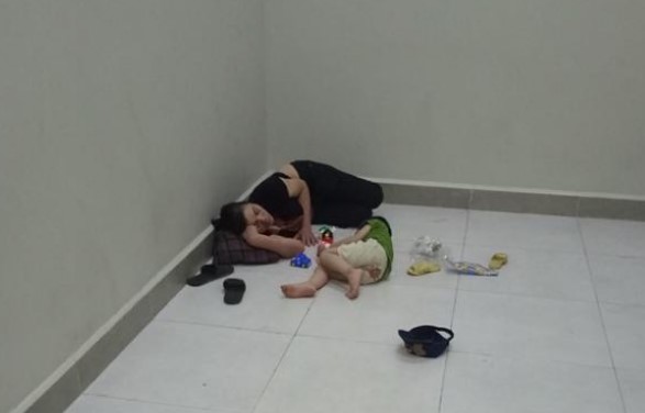 Cảnh 2 mẹ con ngủ đợi lượt khám tại khu vực cầu thang bệnh viện Nhi trung ương.